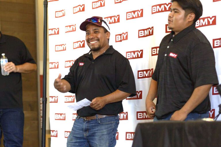 BMY employees being recognized with awards on a stage